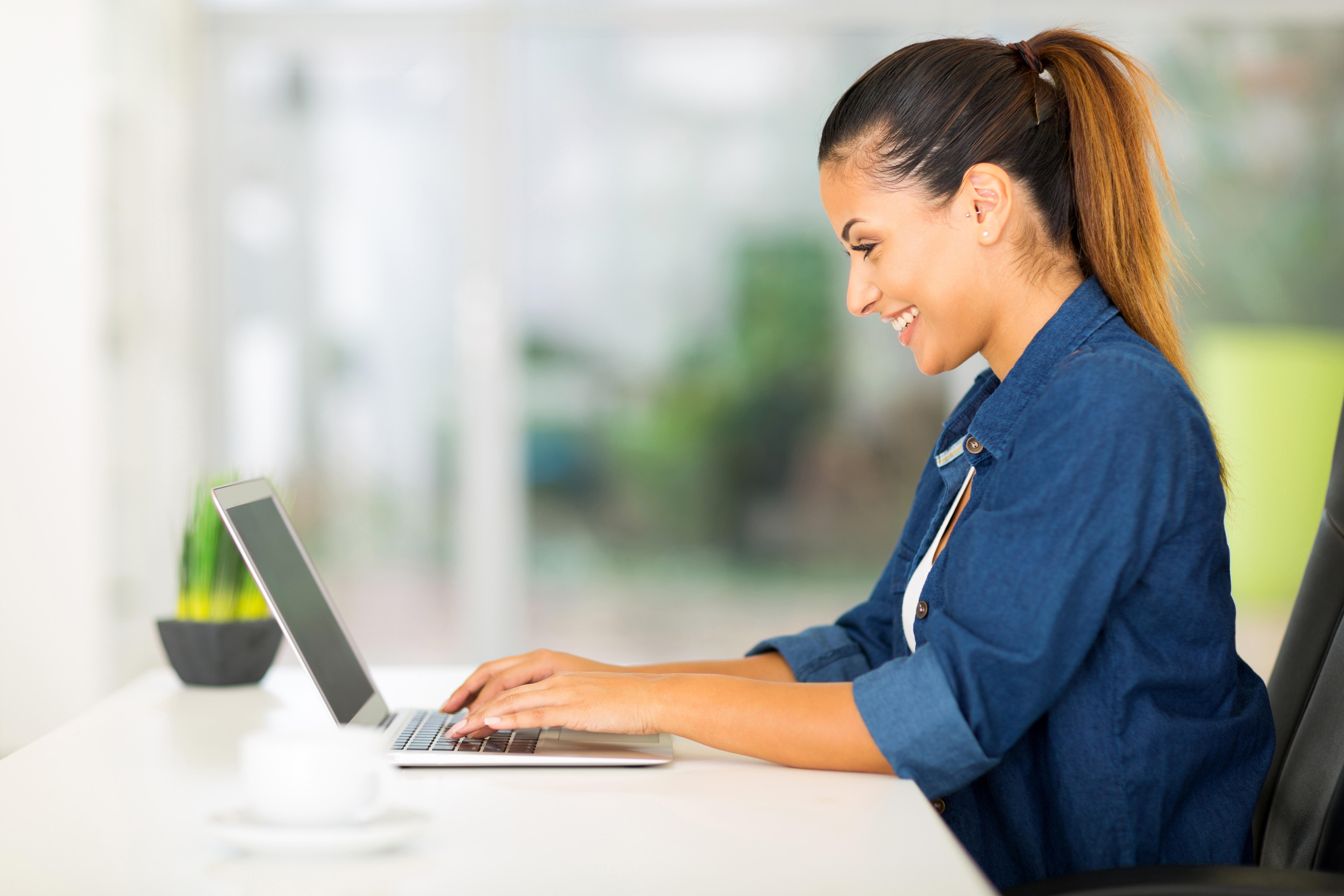 cheerful woman using laptop at home