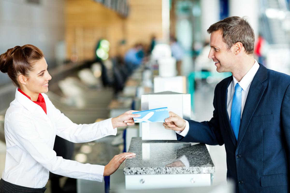 smiling man giving the ticket at the checkin counter